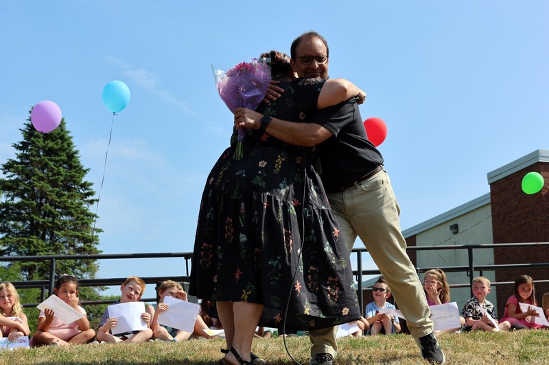 woman giving man with flowers a hug