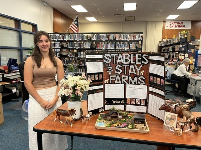 Girl standing next to farm display board