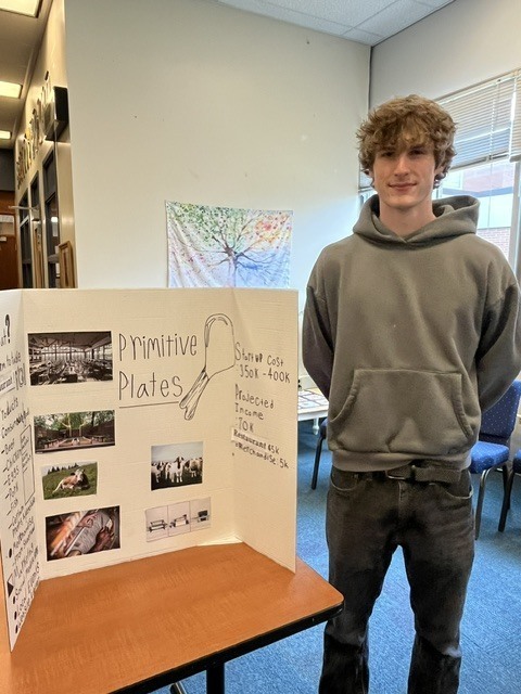 Boy standing next to farm display board
