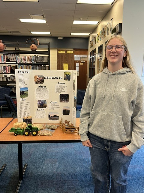 Girl standing next to farm display board