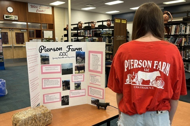 girl standing next to Pierson Farm display