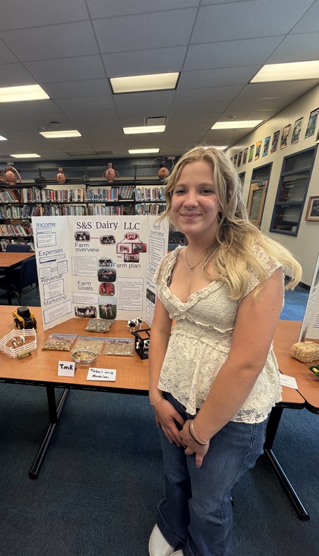 Girl standing next to farm display board