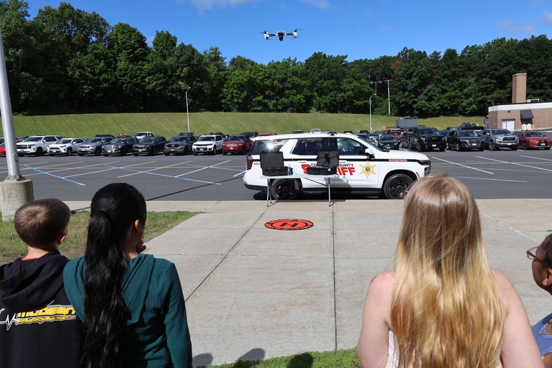 students watching drone fly