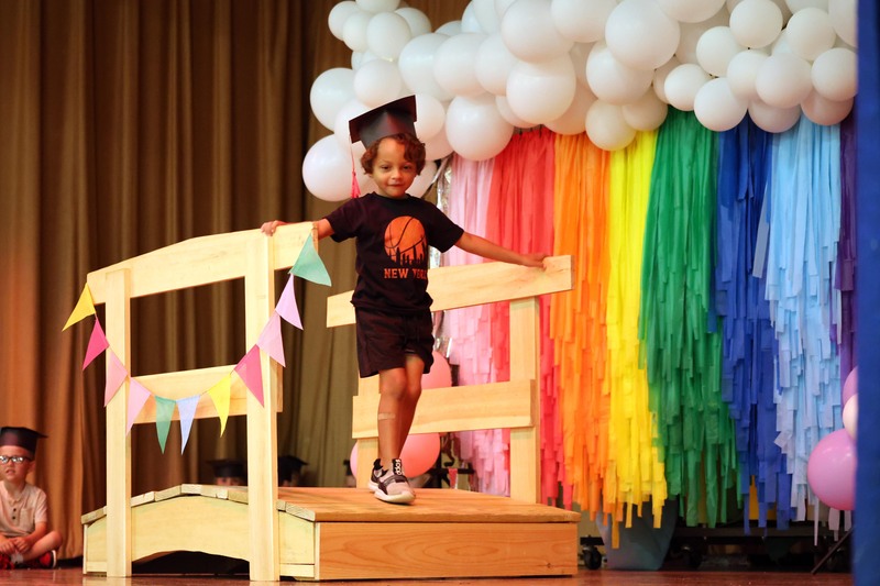 boy crossing wooden bridge on stage