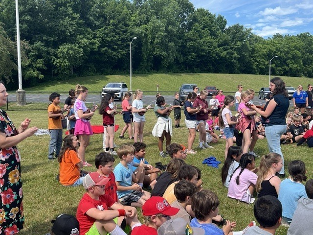 fith grade students playing ukuleles
