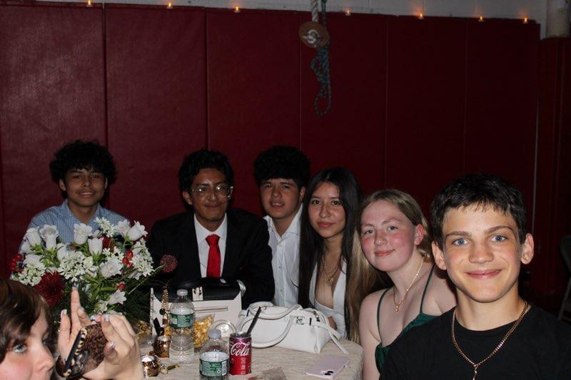 boy and girls in suits and dresses seated at table