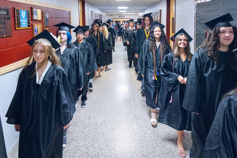 graduates proceeding through school hallway