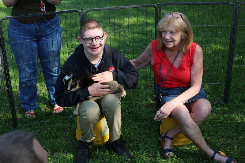 boy holding baby goat