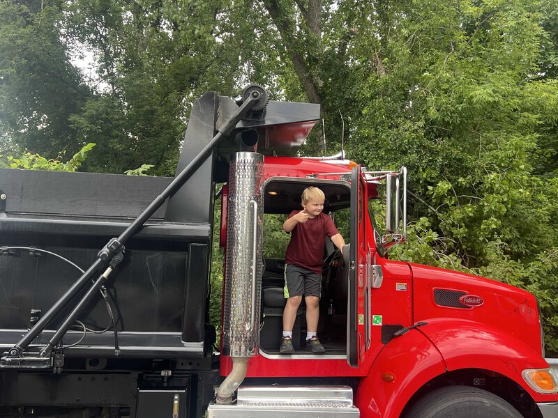 boy in cab of dump truck