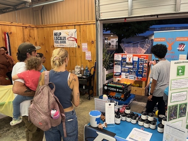 Student showing family robotics display at fair