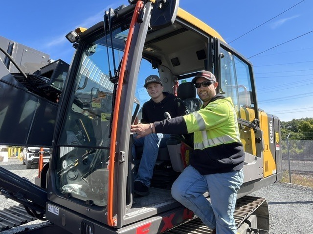 student and man in power shovel