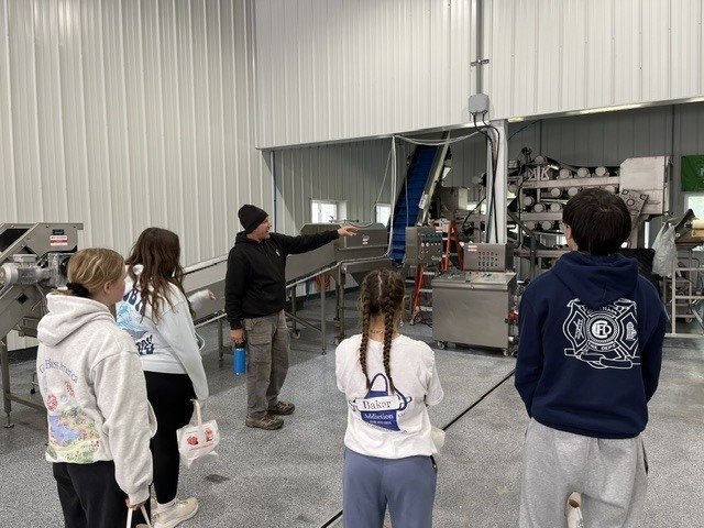 man showing students cider machine