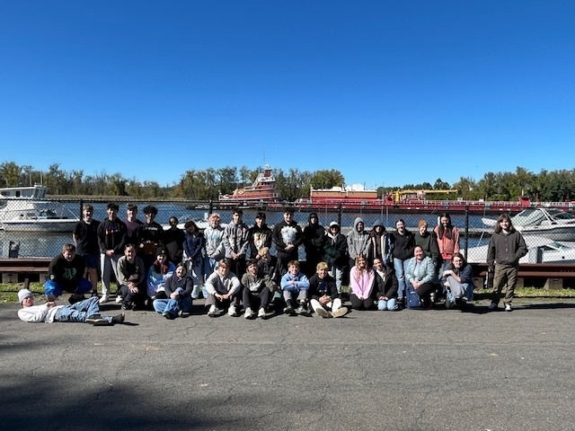 group photo of students and teachers alongside river
