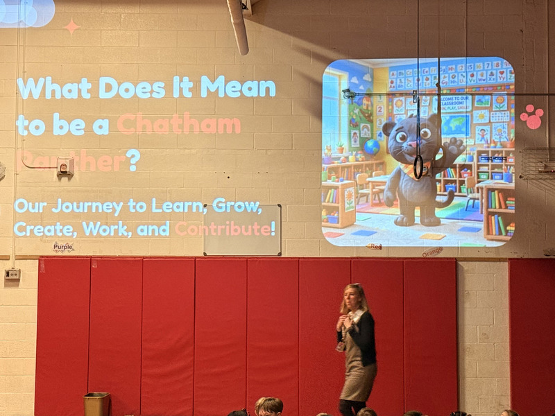 woman speaking to students in front of a projection on the wall asking what it means to be a Chatham Panther