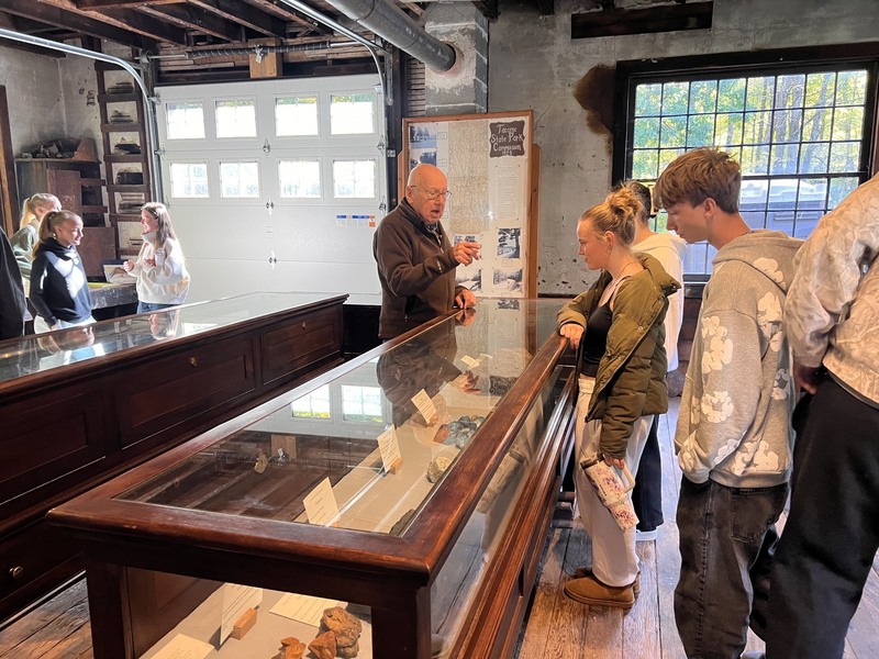 students looking at exhibits in display case