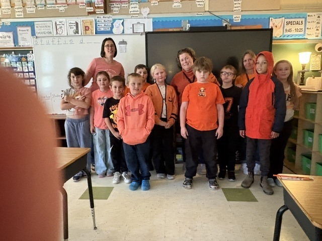 class photo of students wearing orange