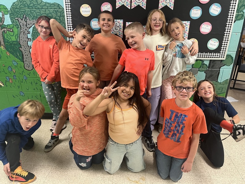 class photo of students wearing orange