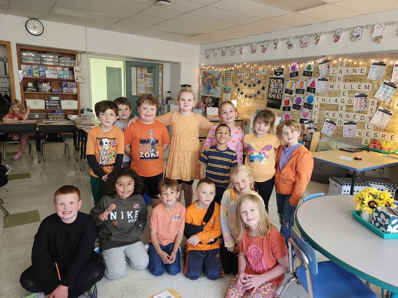 class photo of students wearing orange