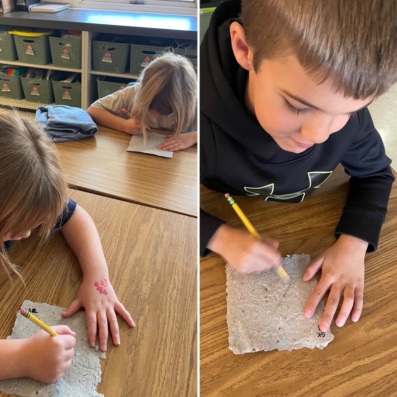 students writing on paper they made