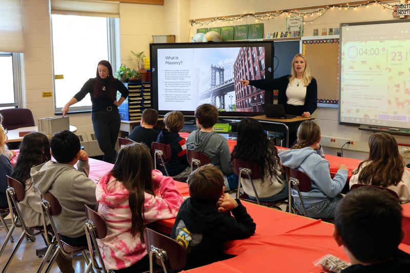 two women presenting about masonry to class of students