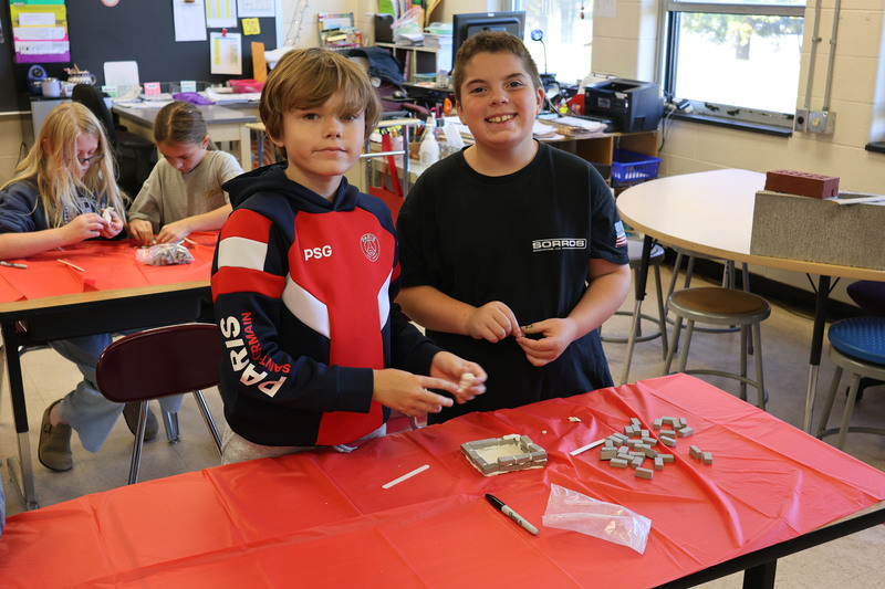 two boys building foundation model with miniature bricks