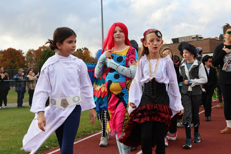 student in costumes march in Halloween parde