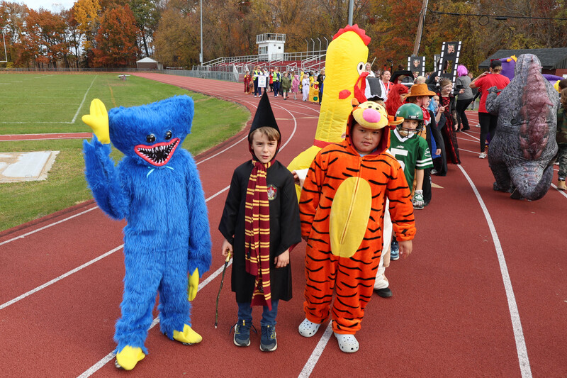 students in costumes march in Halloween parade
