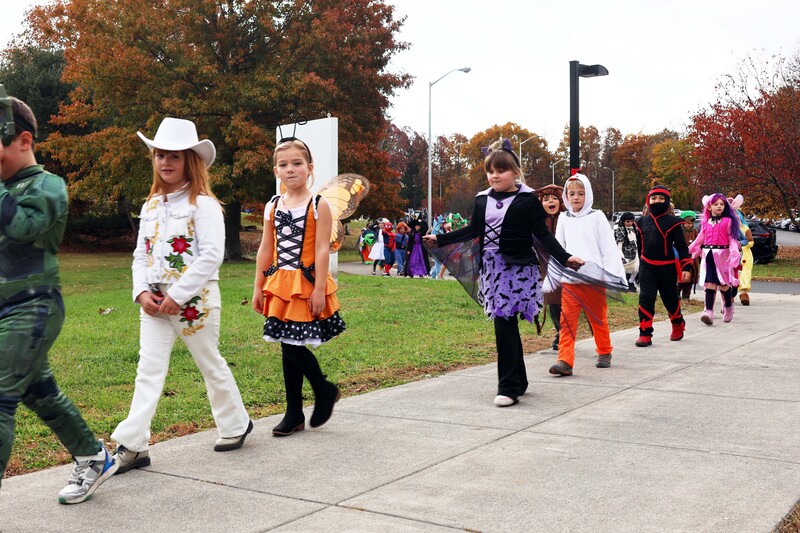 students in costumes march in Halloween parade