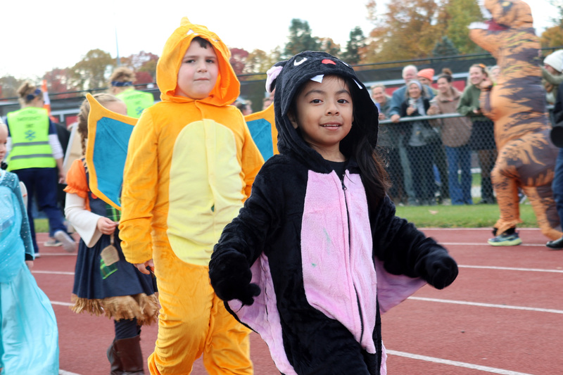 students in costumes march in Halloween parade