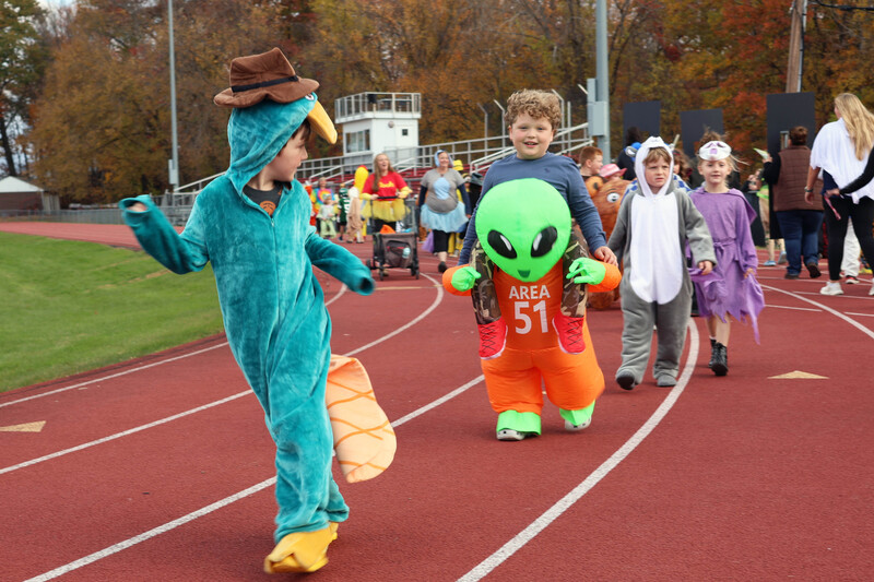 students in costumes march in Halloween parade