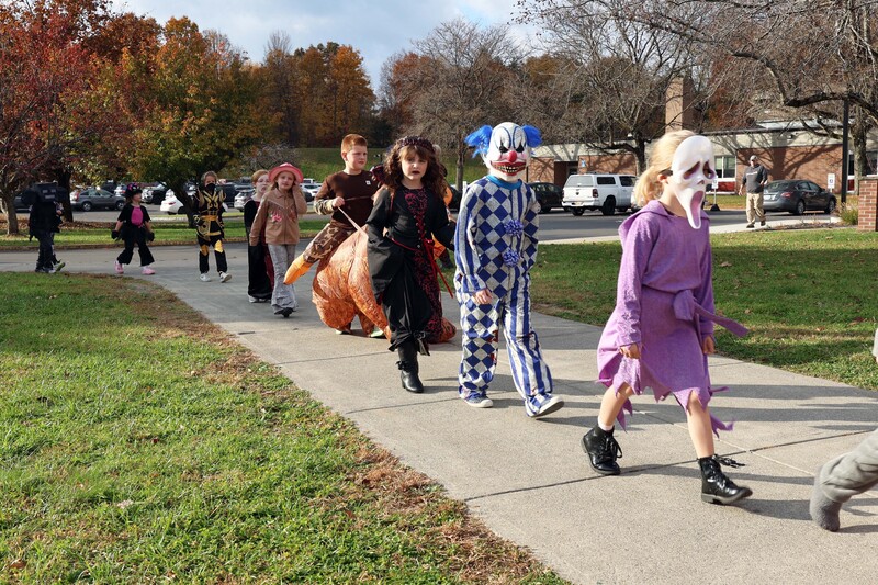 students in costumes march in Halloween parade