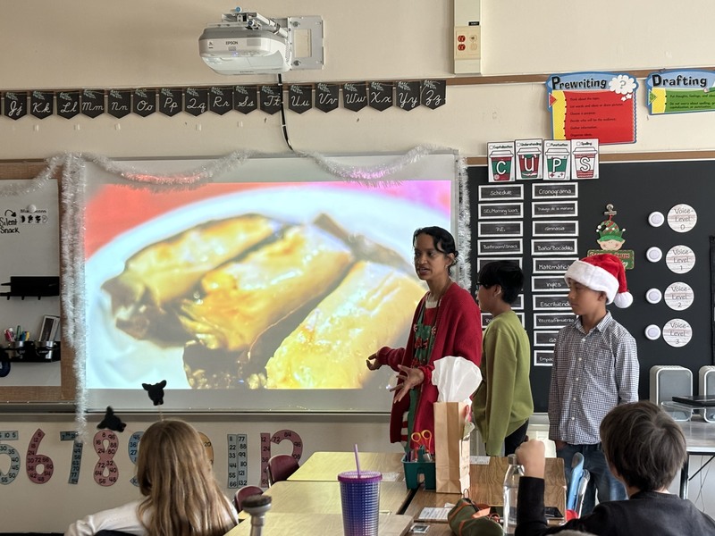 teacher and two boys standing in front of presentation of empanadas