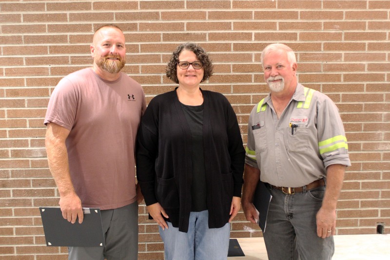 two men and woman posing for photo in Chatham High School hallway