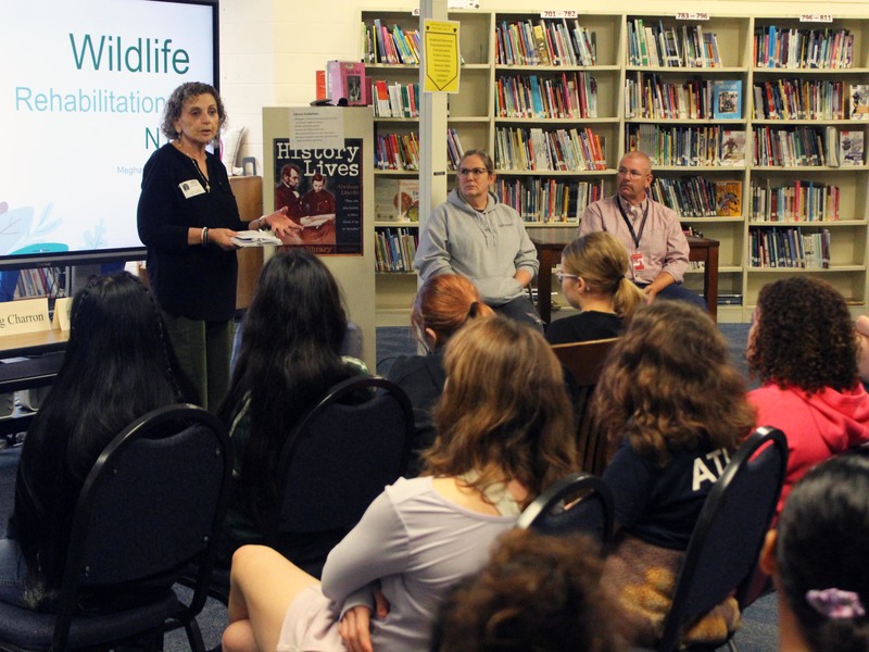 woman talking to students while other panel members look on