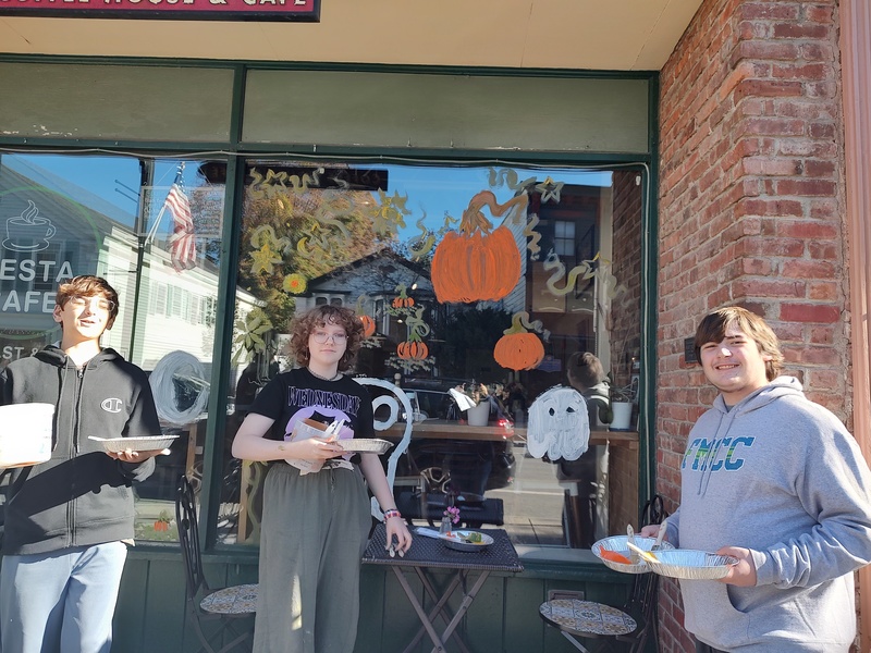 students pose with window they painted