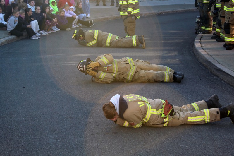 three firefighters demonstrating how to stop drop and roll