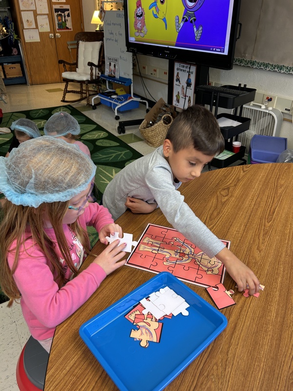 students putting together puzzle
