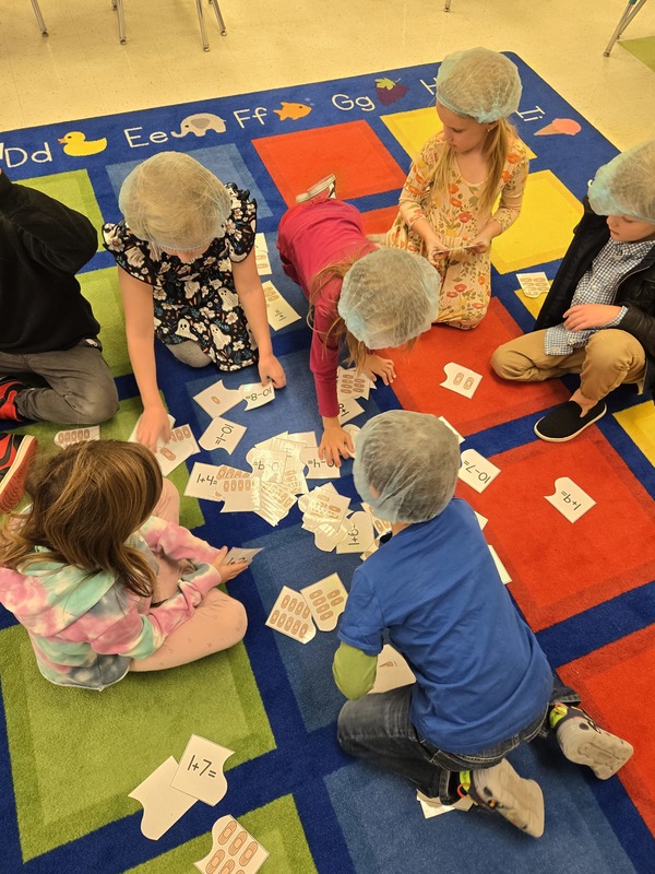 students wearing doctor caps using cards on gloor