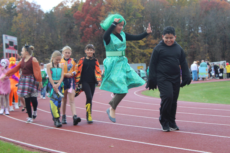 students in Halloween costumes walking on high school track