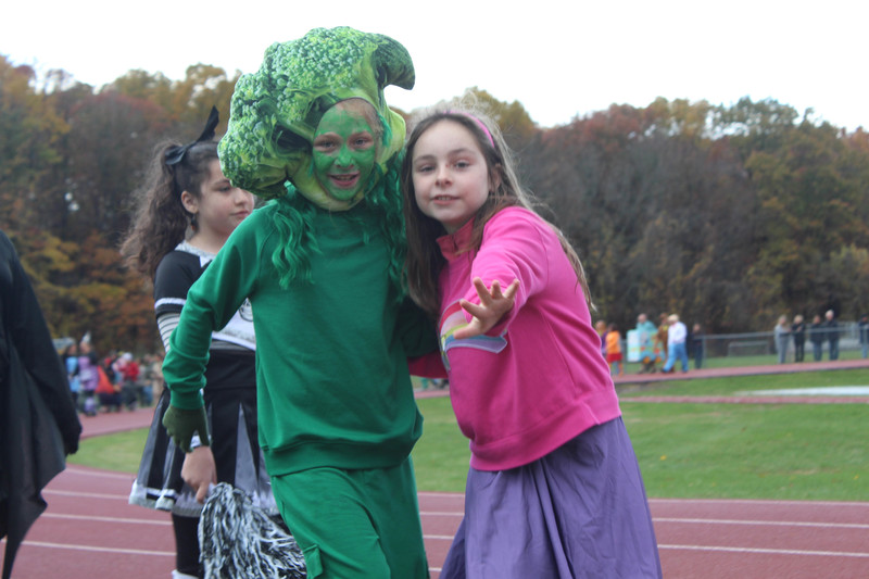 students in Halloween costumes walking on high school track