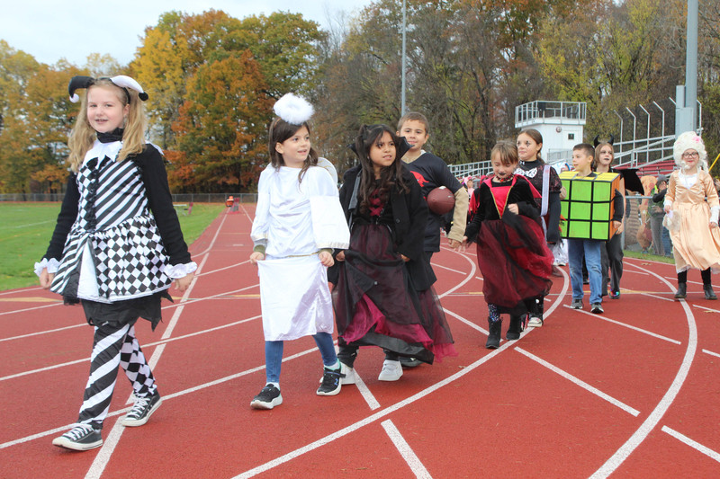 students in Halloween costumes walking on high school track