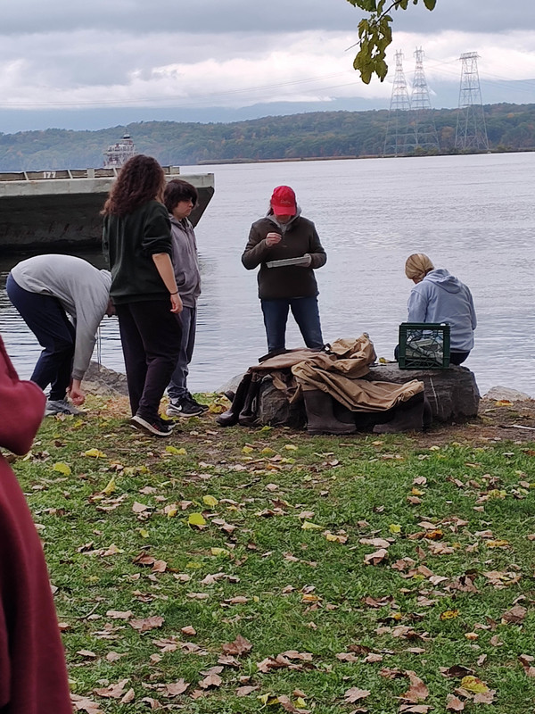students looking at data by side of river