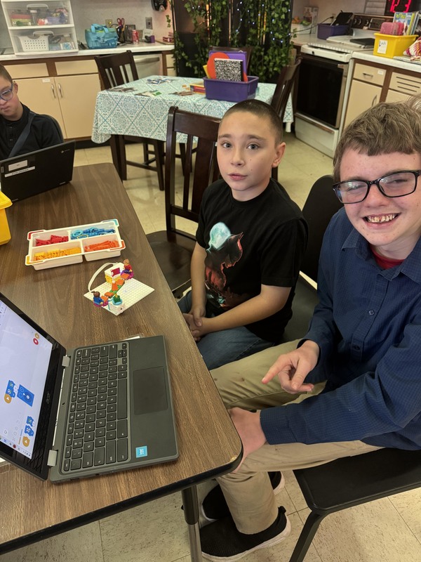 two boys with miniature carousel and laptop
