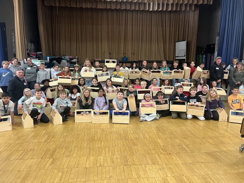 fourth grade poses with wooden toolboxes they  made