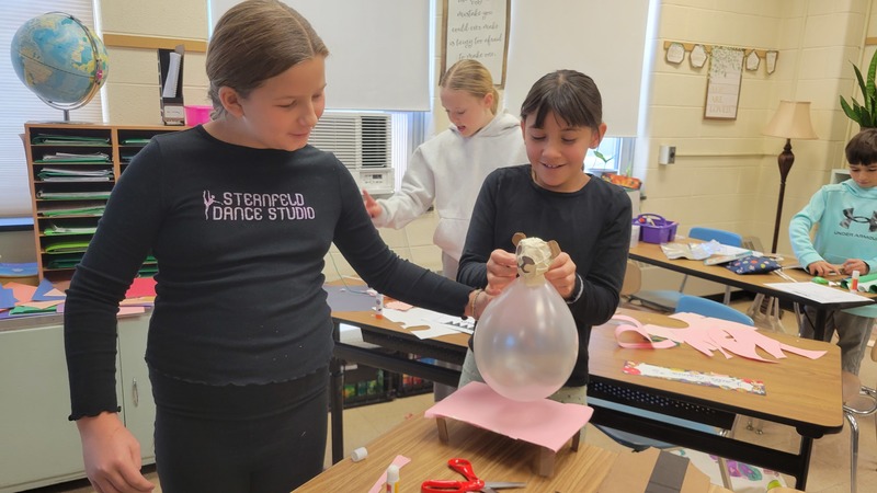 two girls making balloon float model