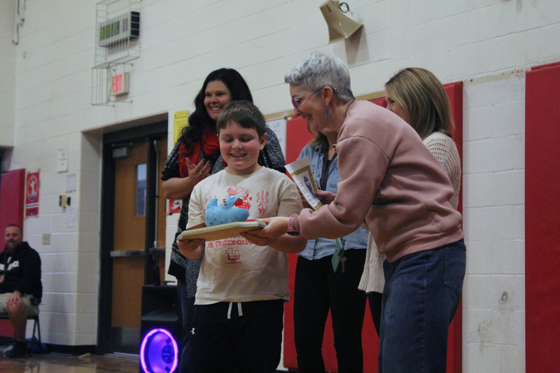 teachers hand boy the Golden Snarg award