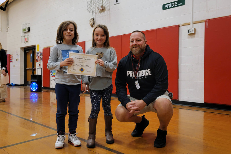 man an d two girls posing with big smiles and a certificate