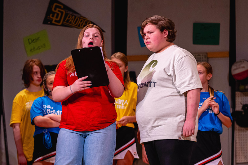 students on stage with clip board