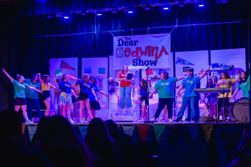 students singing and dancing on stage