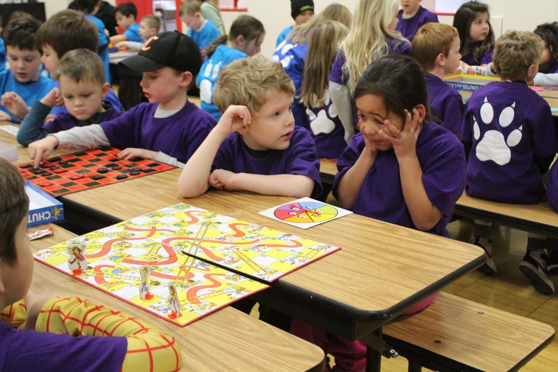 students playing game at cafeteria table